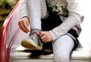 child, girl, tie shoes